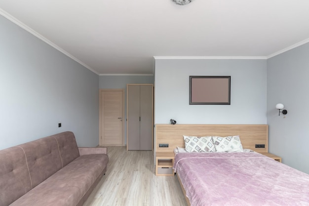 Hotel room with a large double bed in light colors