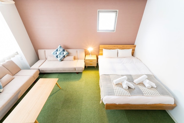 Photo hotel room with sofa, cushions, table and bed