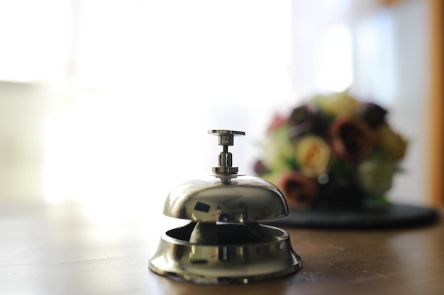 Hotel service bell on wooden reception desk Space for text