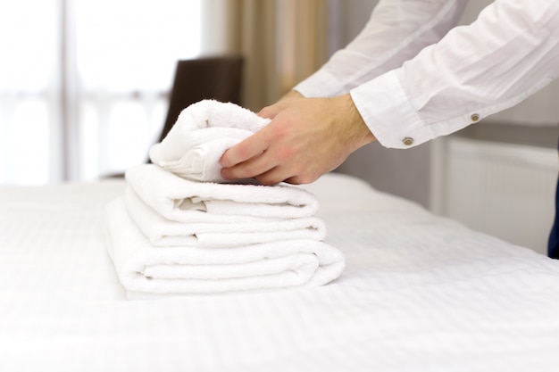 Hotel staff setting up pillow on bed