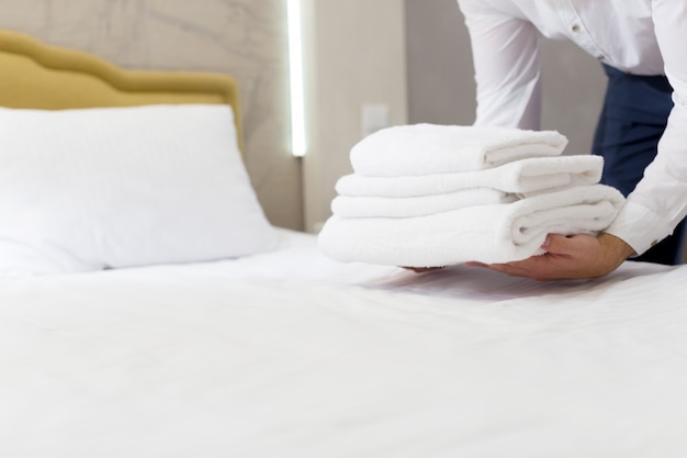Персонал отеля устанавливает подушку на кровати