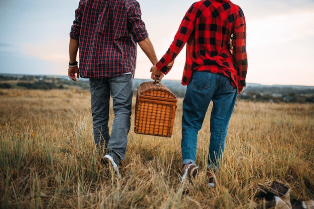 Hou van paar met mand, picknick in zomer veld. Romantisch junket, man en vrouw vrije tijd samen, gelukkig familieweekend