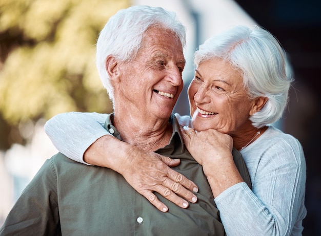 Hou van romantiek en daten met een ouder stel dat samen buiten in de natuur knuffelt tijdens hun pensionering