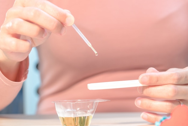 houd de zwangerschapstest vast terwijl je de urine laat vallen