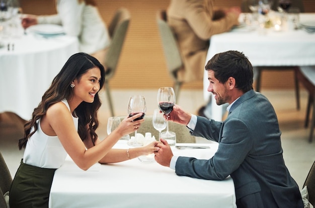 Houd van wijn en proost met een stel in een restaurant voor hun jubileumfeest of romantisch diner Nachtbril of dates met een jonge man en vrouw die samen een evenement vieren met gejuich