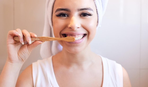 Houd ze wit en beschermd. Portret van een mooie jonge vrouw die haar tanden thuis schoonmaakt.