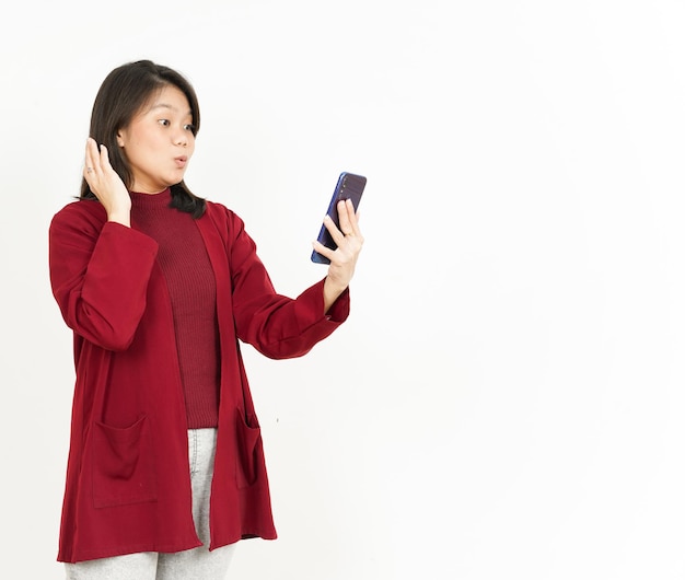 Houden en gebruiken van Smartphone van mooie Aziatische vrouw met rood shirt geïsoleerd op een witte achtergrond