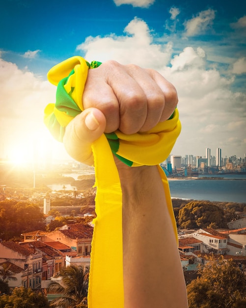 Houden groene en gele linten van de vlag van Brazilië geïsoleerd op de achtergrond van de stad Fan juichen voor Brazilië om de kampioen te worden