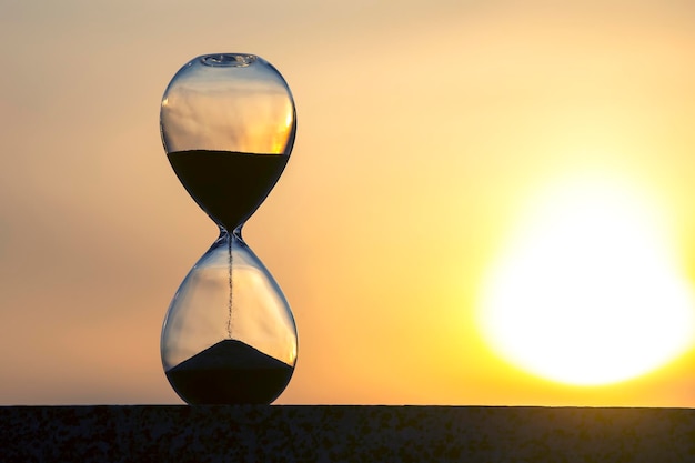 Hourglass on the background of a sunset The value of time in life An eternity