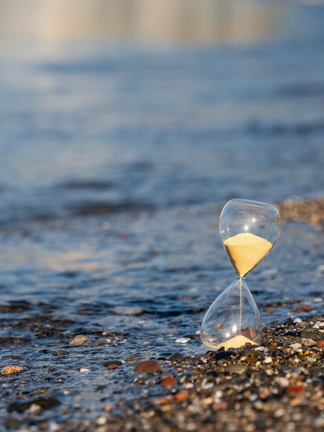 Hourglass on the beach at the seashore