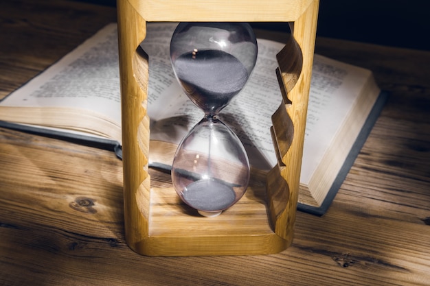 Photo hourglass and book on the table