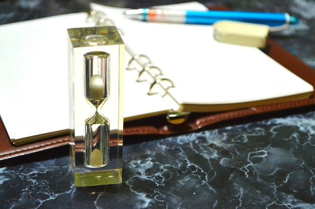 Photo hourglass and books on table