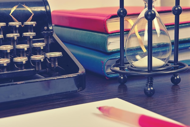 Hourglass books and vintage typewriter