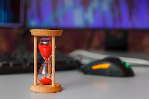 Hourglass on a keyboard on a background of diagrams