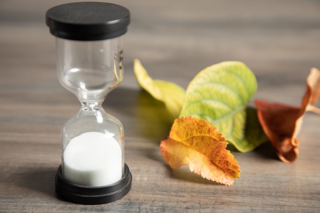 Hourglass and leaves on the table