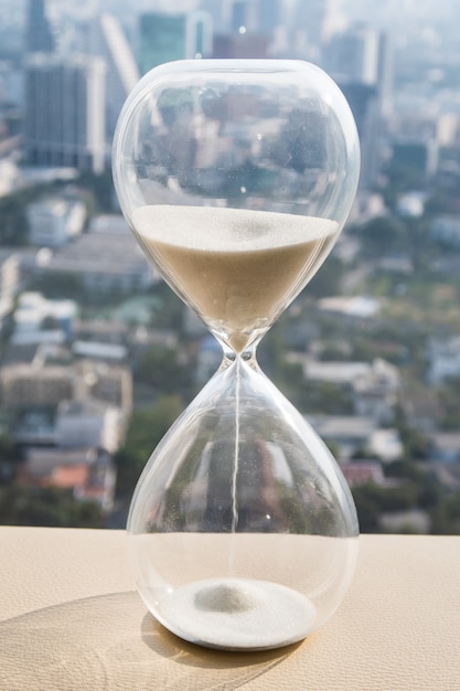 Hourglass or sandglass with cityscape background