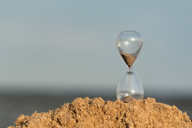 Hourglass on seashore sky on background Time concept