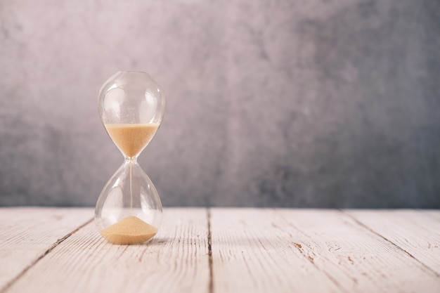 Hourglass on table, Sand flowing through the bulb of Sandglass.