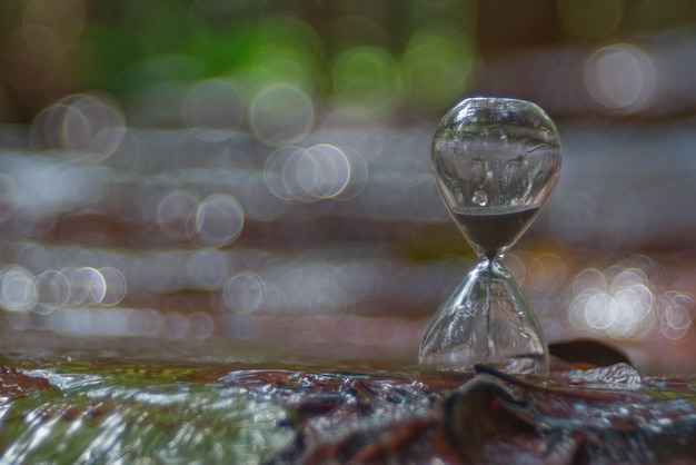 An hourglass with blur waterfall in background