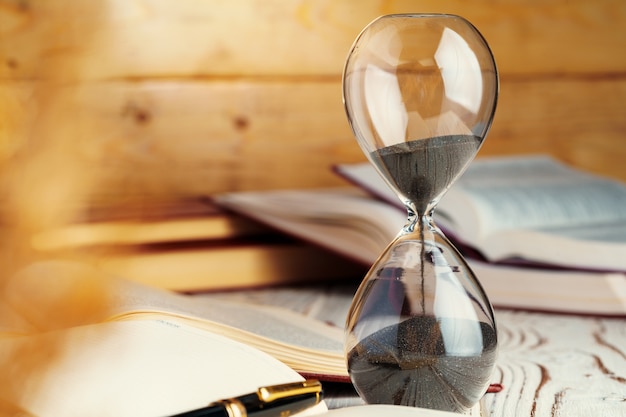 Photo hourglass with sand close up on wooden background