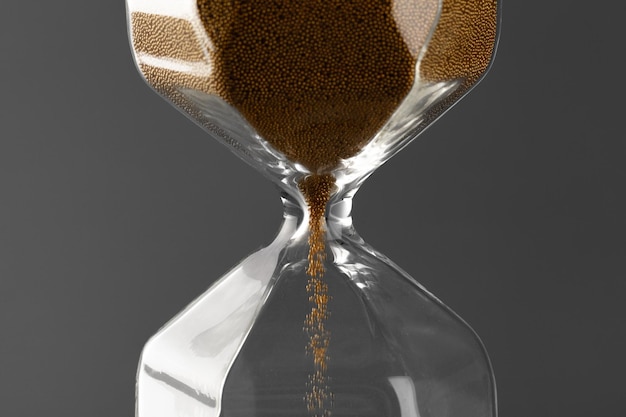 Photo hourglass with sand on gray background close up