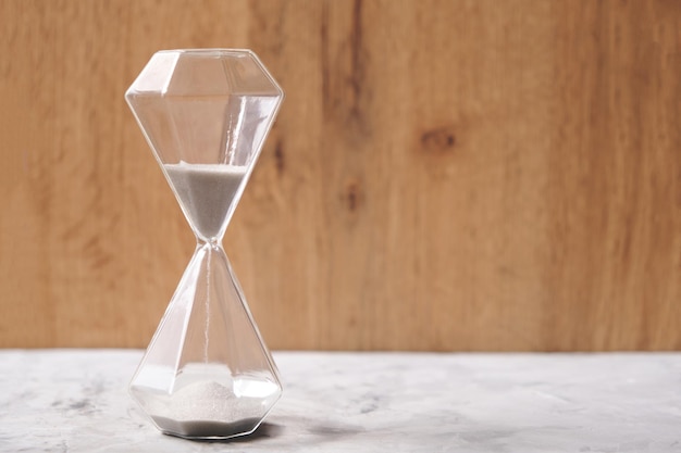 Hourglass on a wooden background, passing time.