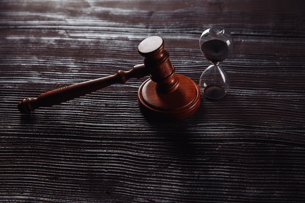 Hourglass and wooden judge gavel on a table