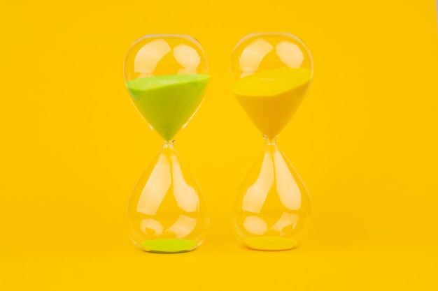 Hourglass on yellow background time and countdown time limit for urgent work to meet deadlines