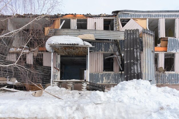 The house after the gas explosion and fire A burntout multiapartment frame house sheathed with a metal profiled sheet