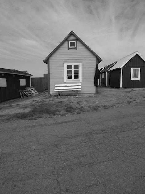 Photo house on beach by buildings against sky