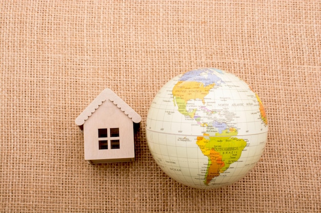 House beside a globe placed on canvas background