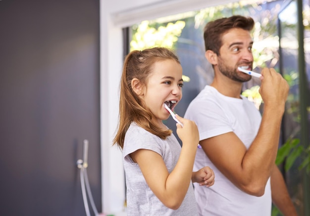house brushing teeth and father with girl cleaning mouth and morning routine with grooming family dad and daughter with fresh breath dental hygiene and oral care with dental wellness and playful