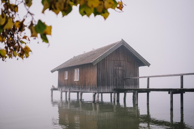 House by lake against clear sky