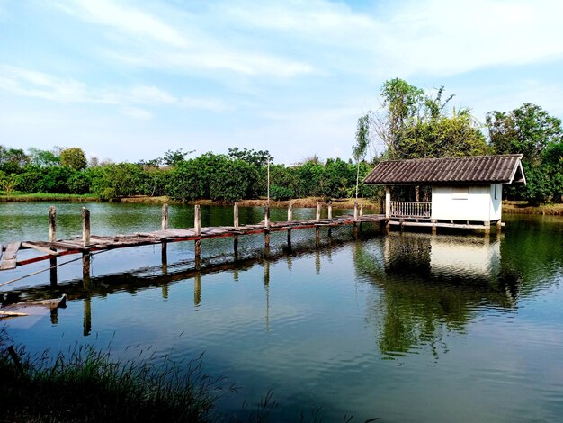 House by lake against sky