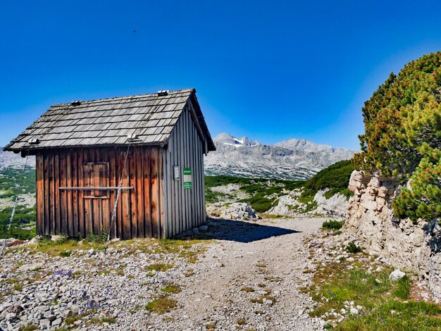 Foto casa vicino alla montagna contro un cielo blu limpido