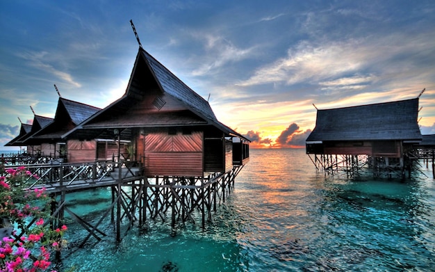 a house by the water with a sky background