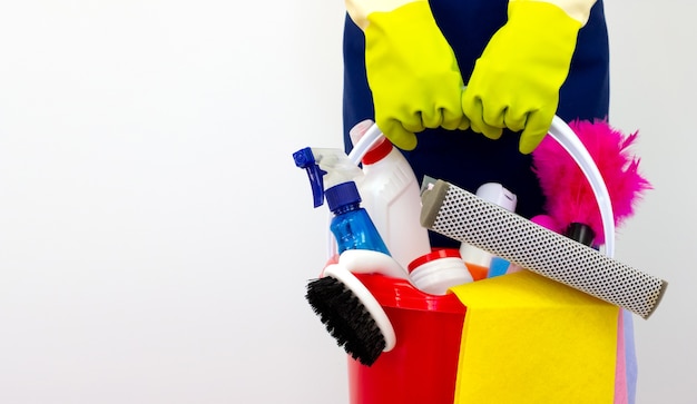 Photo house cleaning products pile in hand with green gloves on white background. consept cleaning service