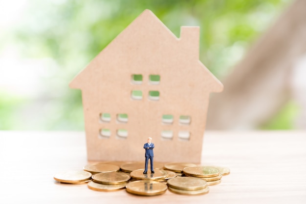 House and coins on table.