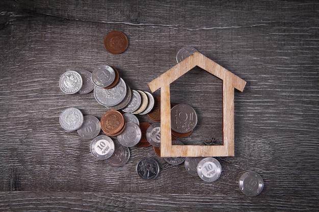 House and coins on the table