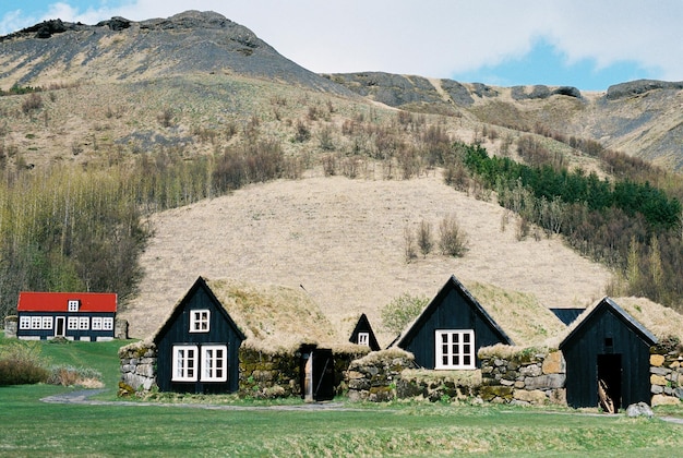 Photo house on field against mountain