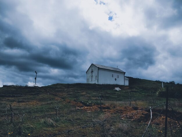 Photo house on field against sky