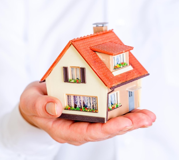 house in human hands on a white background