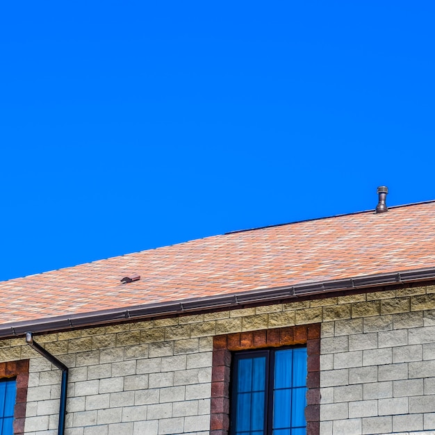 Photo the house is made of beige bricks the roof is covered with bitumen shingles metal plastic windows on the house