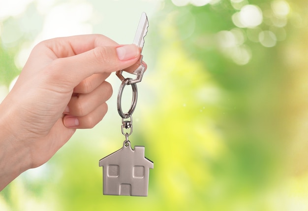 House key in hand on blurred background