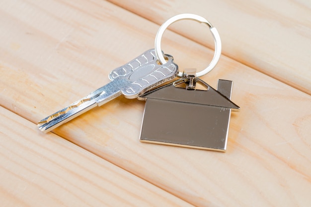 Foto chiave di casa con portachiavi casa sul tavolo di legno