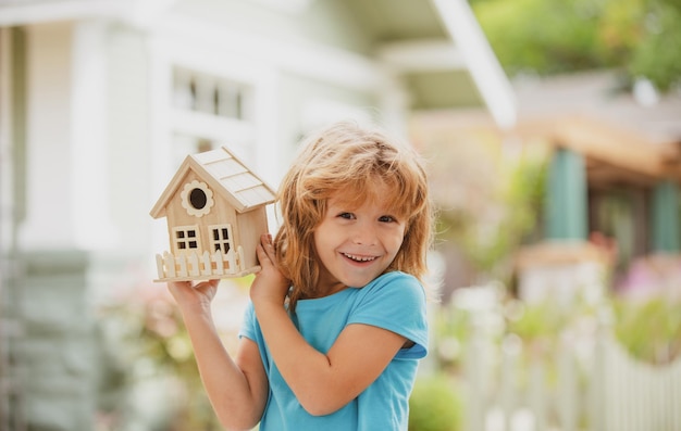 子供の手の中の家家族の家の家を守る保険の概念子供男の子の家の家の世話を構築する幸せな子供の針仕事の概念Diyプロジェクト