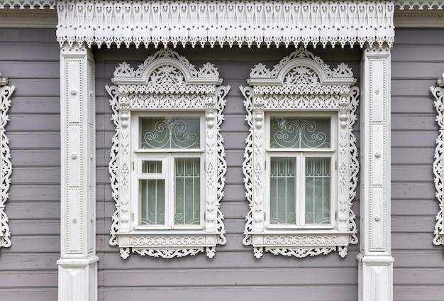 古代の町の古い家の彫刻が施された木製のトリムが付いたコロムナ窓のLvovsの家
