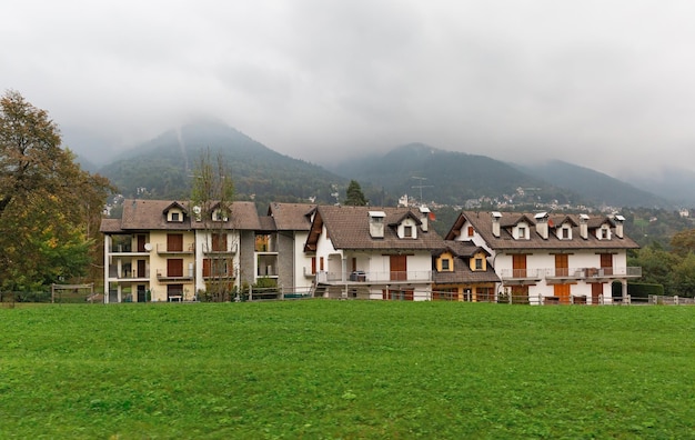 Casa nel prato sullo sfondo delle montagne nella nebbia