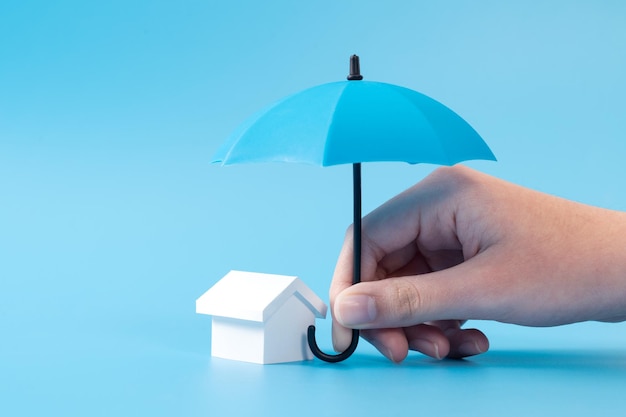 Модель дома под зонтиком синего цвета