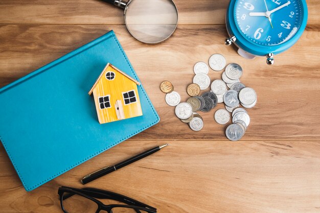 Photo house model on book with coins on table